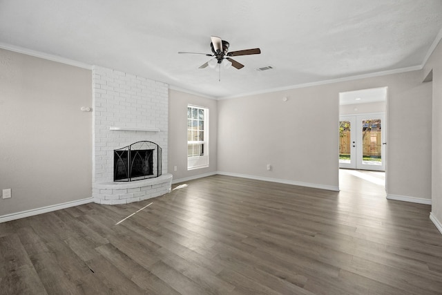 unfurnished living room featuring ceiling fan, ornamental molding, dark hardwood / wood-style flooring, and a brick fireplace