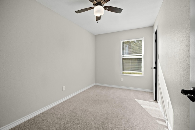 carpeted spare room with ceiling fan