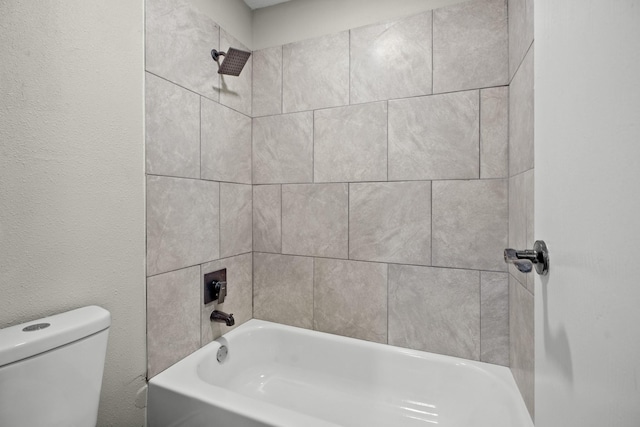 bathroom with toilet and tiled shower / bath