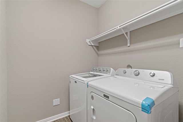 laundry room featuring wood-type flooring and washing machine and clothes dryer