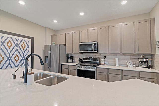 kitchen with sink, backsplash, gray cabinetry, and stainless steel appliances