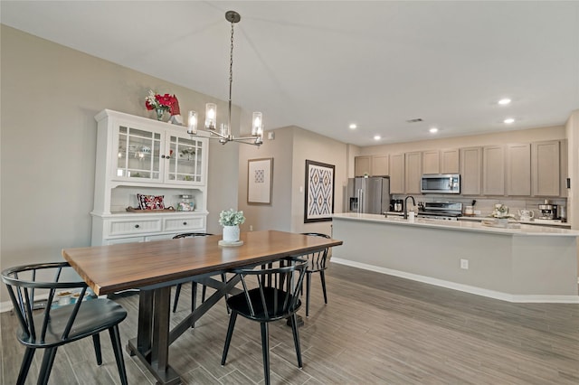 dining room featuring sink, hardwood / wood-style floors, and a notable chandelier