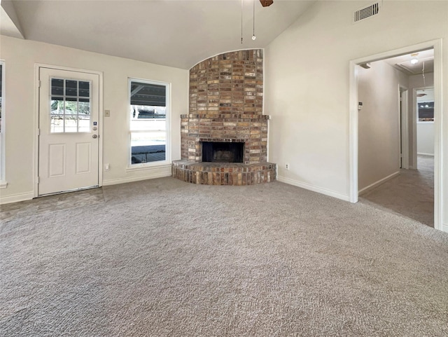 unfurnished living room with ceiling fan, lofted ceiling, a fireplace, and carpet floors