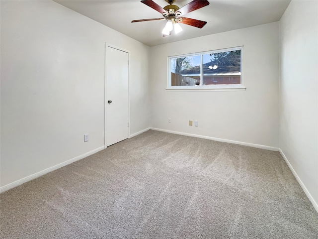 carpeted spare room featuring ceiling fan