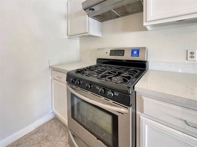 kitchen with stainless steel gas stove, white cabinets, and range hood