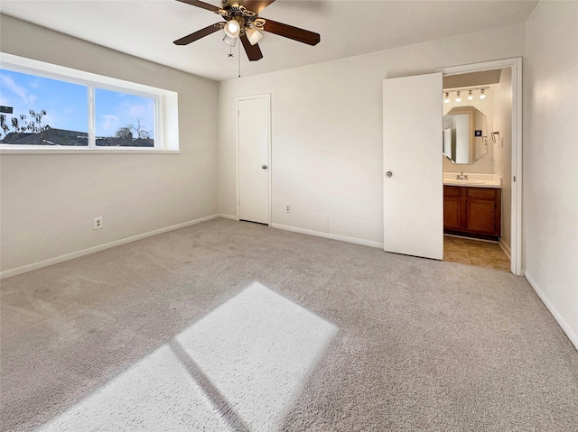 unfurnished bedroom with light carpet, ceiling fan, connected bathroom, a closet, and sink