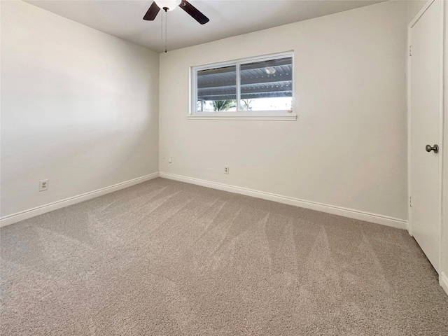 empty room featuring ceiling fan and carpet