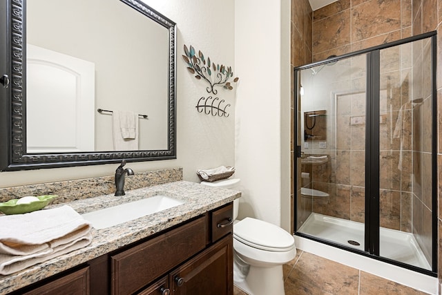 bathroom with an enclosed shower, vanity, and toilet