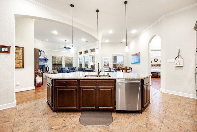 kitchen with a center island with sink, ceiling fan, light stone countertops, stainless steel dishwasher, and sink