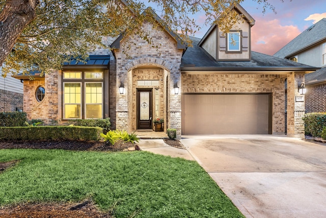 view of front facade featuring a garage and a lawn