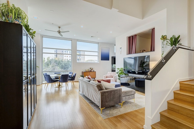 living room featuring ceiling fan and light hardwood / wood-style floors