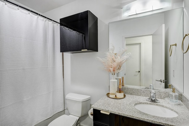 bathroom with toilet, vanity, and curtained shower