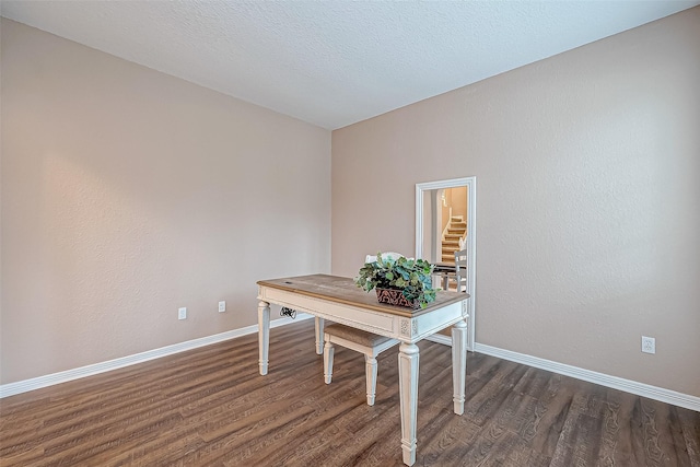 unfurnished office with a textured ceiling and dark hardwood / wood-style floors