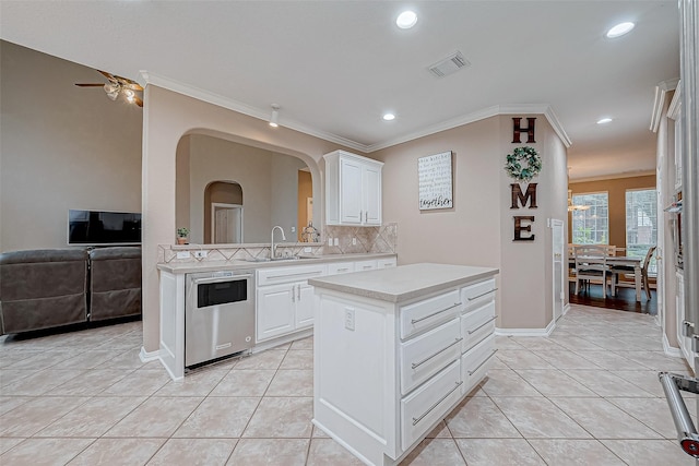 kitchen featuring ceiling fan with notable chandelier, a kitchen island, backsplash, and white cabinets