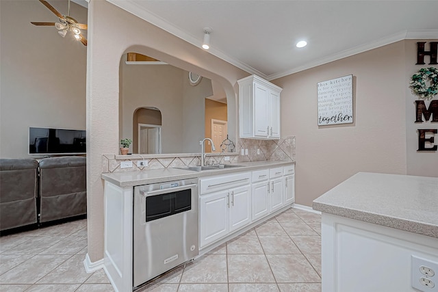 kitchen with white cabinetry, decorative backsplash, sink, light tile patterned flooring, and crown molding