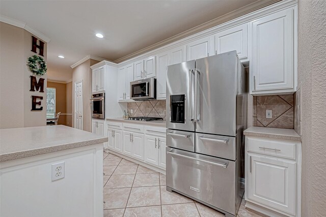 kitchen featuring white cabinets, stainless steel appliances, and ornamental molding