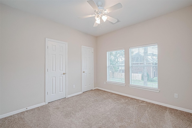 carpeted spare room with ceiling fan