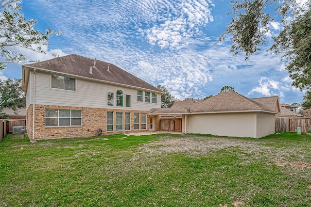 back of property with cooling unit and a yard