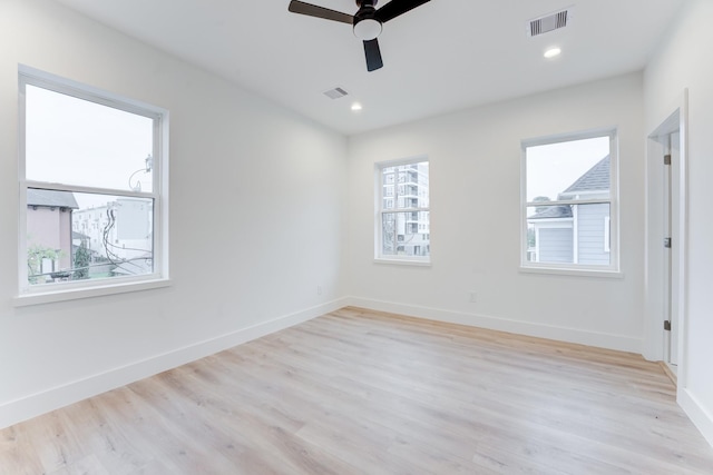 unfurnished room featuring ceiling fan, a healthy amount of sunlight, and light wood-type flooring