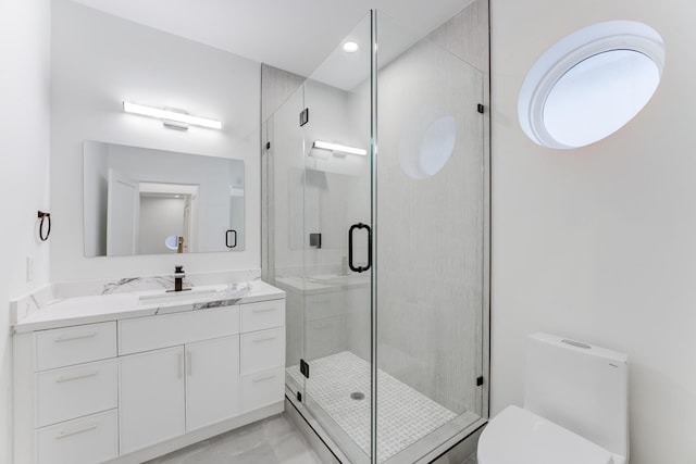 bathroom with a shower with door, vanity, and toilet