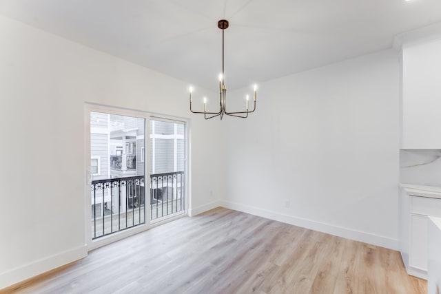 unfurnished dining area featuring light hardwood / wood-style flooring and a chandelier