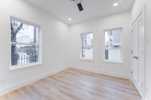 unfurnished room featuring ceiling fan, a healthy amount of sunlight, and light wood-type flooring