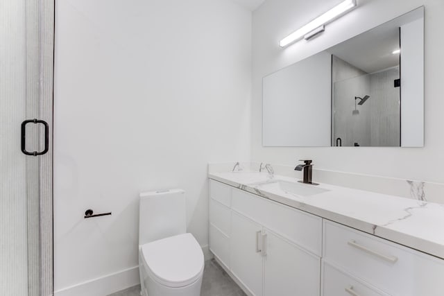 bathroom featuring vanity, a shower with shower door, and toilet