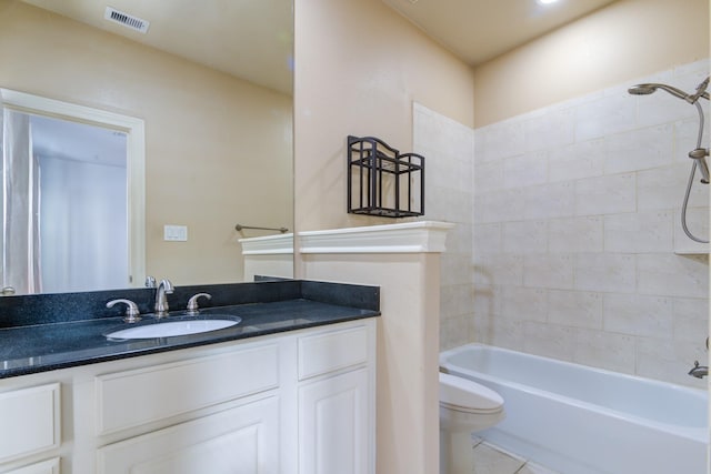 full bathroom with toilet, tile patterned flooring, tiled shower / bath, and vanity