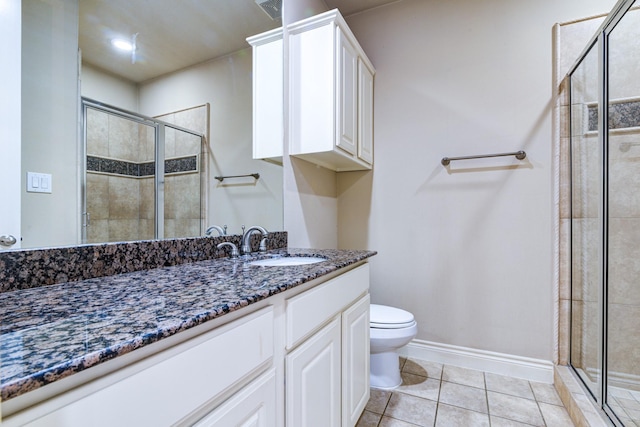 bathroom with walk in shower, vanity, tile patterned floors, and toilet