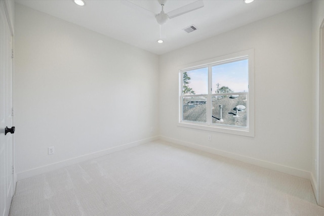 spare room featuring light carpet and ceiling fan