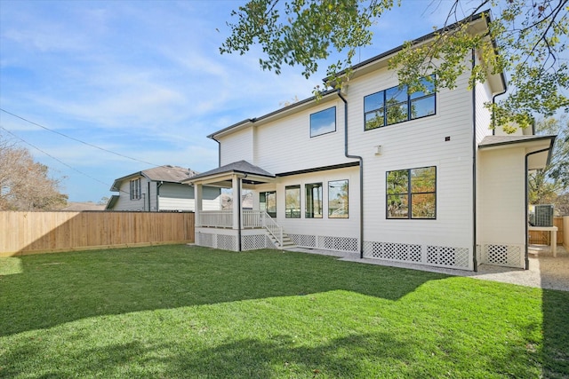 back of house featuring cooling unit and a yard