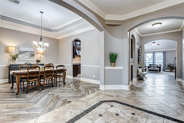 dining area featuring ceiling fan with notable chandelier and ornamental molding