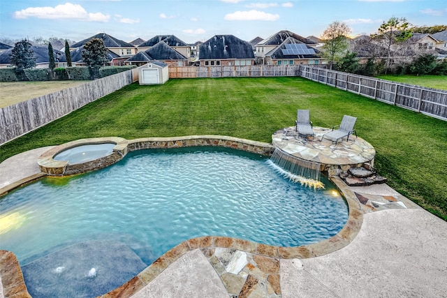 view of pool with a storage shed, an in ground hot tub, a patio, a yard, and pool water feature