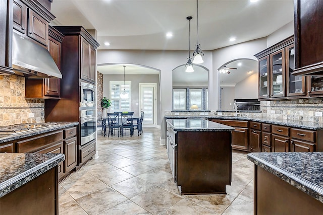 kitchen with ceiling fan, stainless steel appliances, hanging light fixtures, dark brown cabinetry, and sink