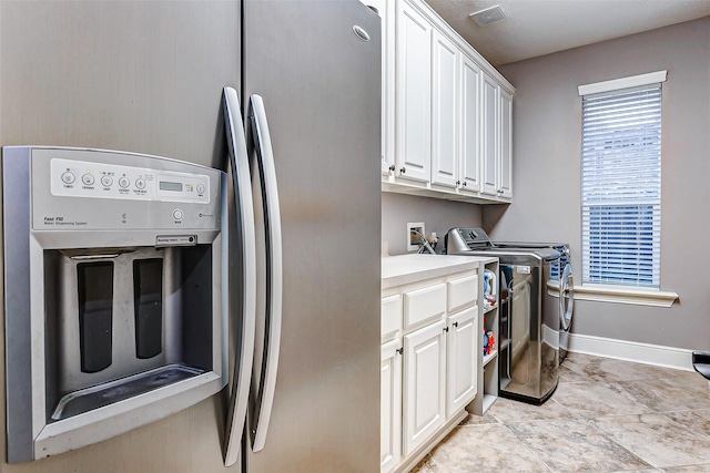 clothes washing area featuring cabinets and independent washer and dryer