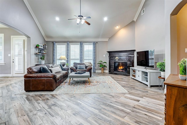 living room featuring ceiling fan, ornamental molding, lofted ceiling, and light hardwood / wood-style flooring