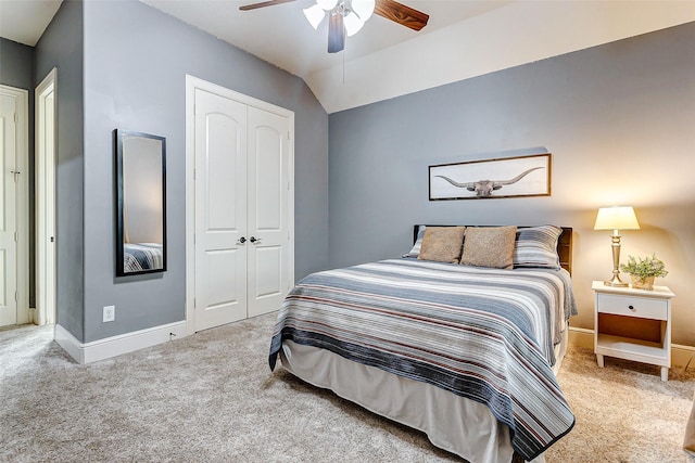 bedroom with lofted ceiling, ceiling fan, carpet flooring, and a closet