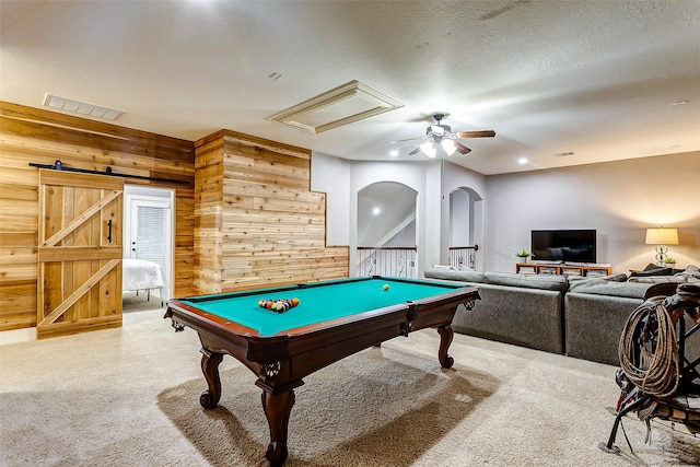 rec room featuring ceiling fan, a barn door, billiards, wood walls, and a textured ceiling