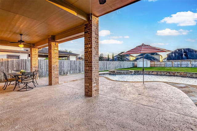 view of patio featuring ceiling fan and a shed