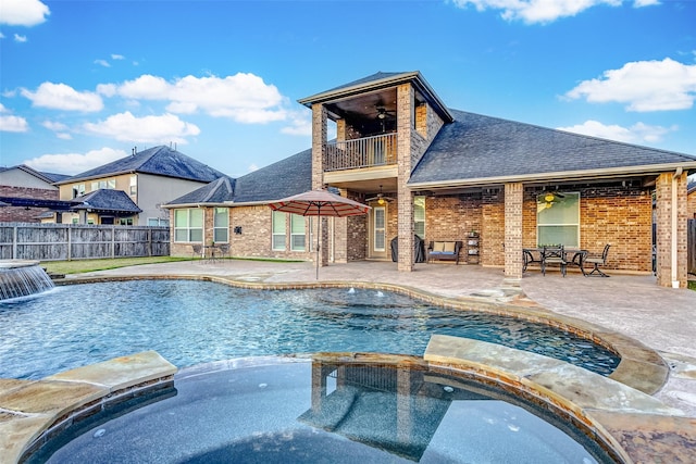 view of pool with ceiling fan, a patio area, an in ground hot tub, and pool water feature