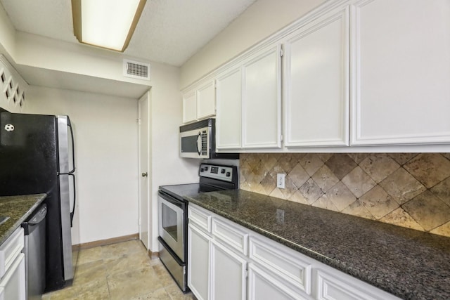 kitchen with decorative backsplash, dark stone countertops, stainless steel appliances, and white cabinetry