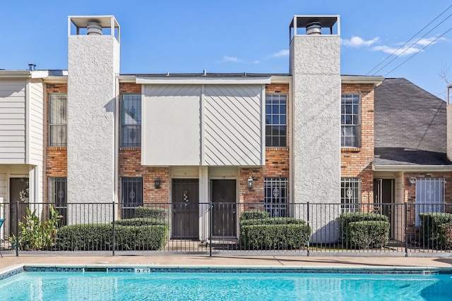 rear view of house with a community pool