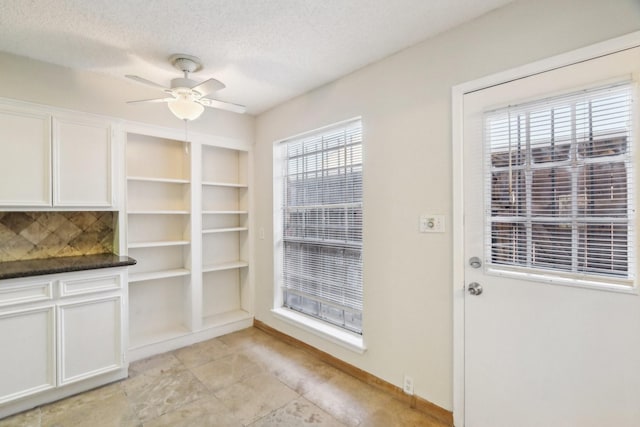 interior space featuring ceiling fan and a textured ceiling