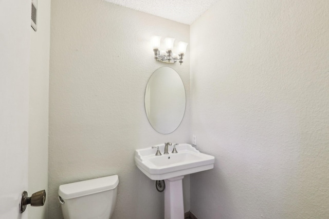 bathroom featuring sink, a textured ceiling, and toilet