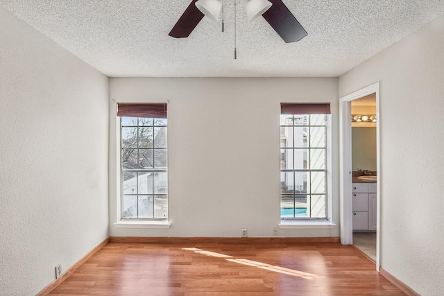 spare room featuring ceiling fan, a wealth of natural light, hardwood / wood-style flooring, and sink