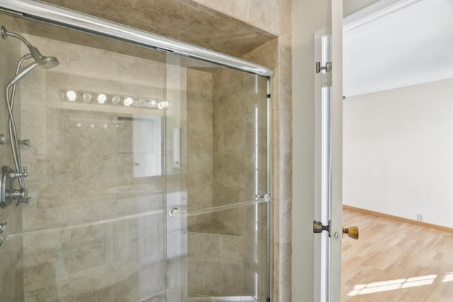 bathroom with hardwood / wood-style flooring and a shower with door