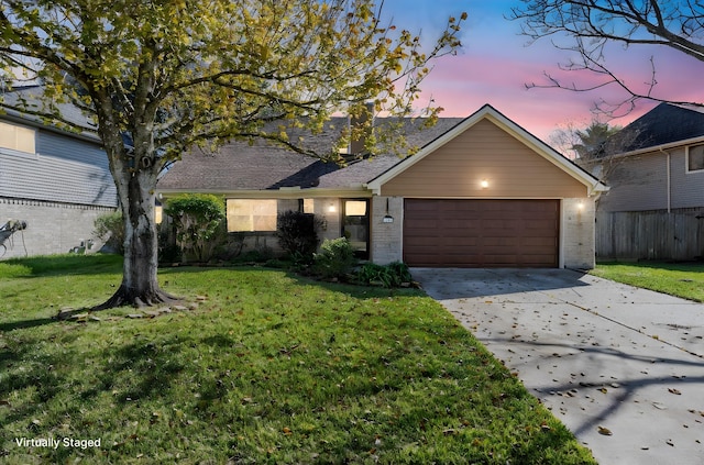 single story home with a garage and a lawn