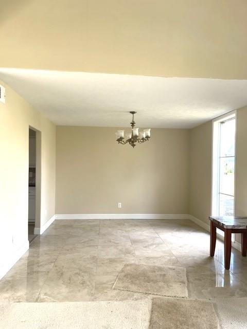 empty room featuring a chandelier