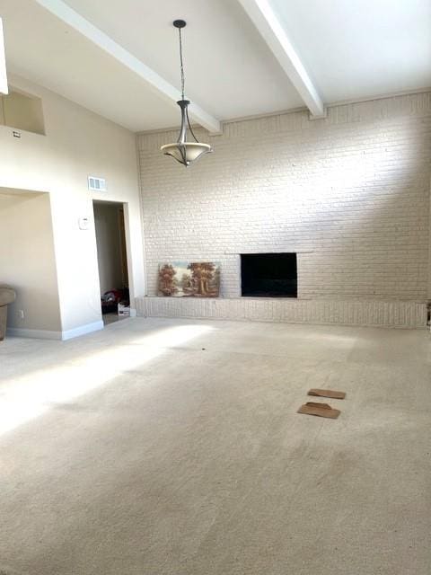 unfurnished living room with a fireplace, beamed ceiling, and carpet flooring