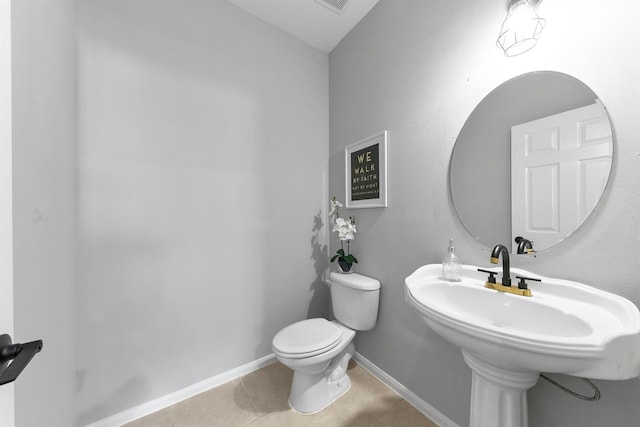 bathroom with toilet, tile patterned flooring, and sink